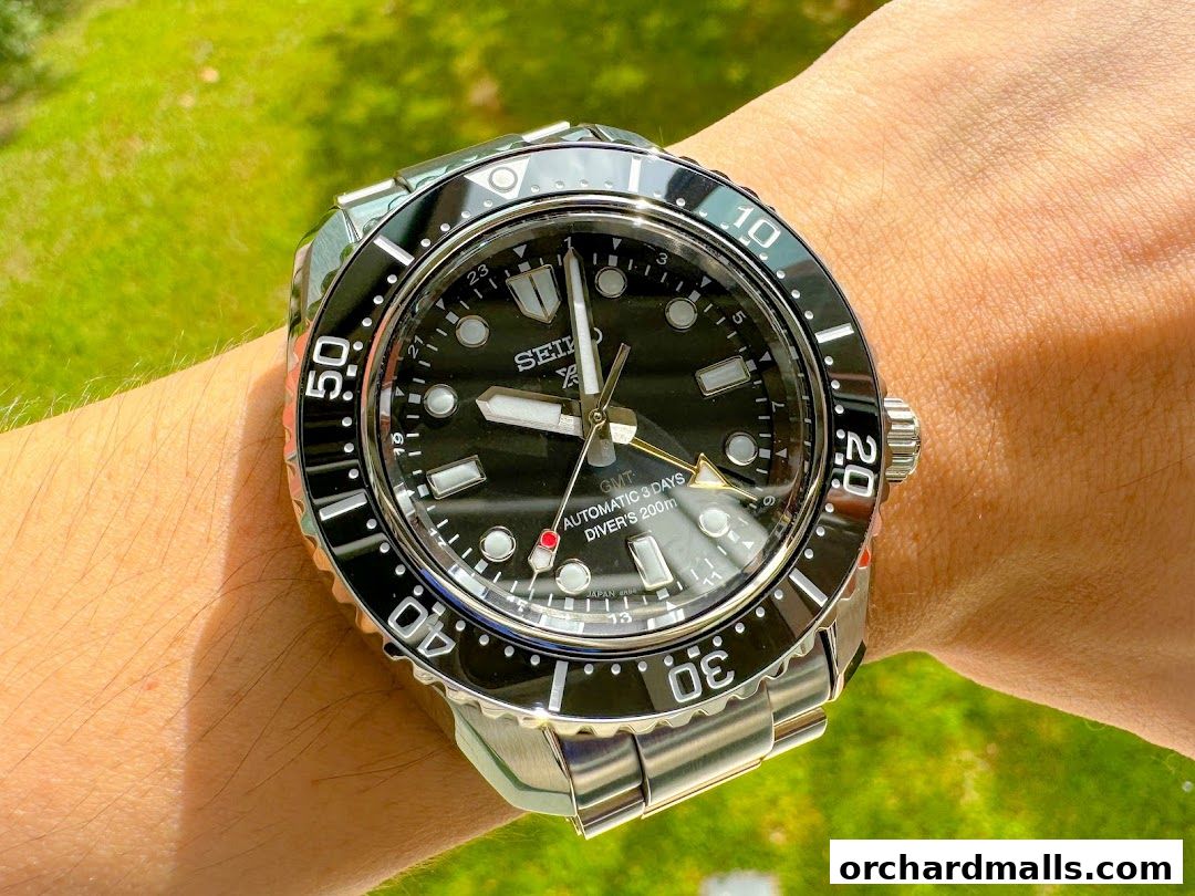 A close-up shot of a Seiko automatic diver's watch with a black dial on a wrist.