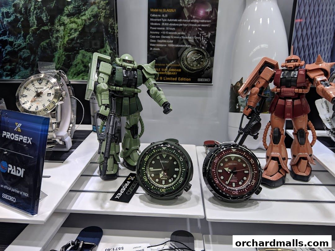 Display of Seiko watches and Gundam figurines, showcasing a blend of timepieces and collectibles.