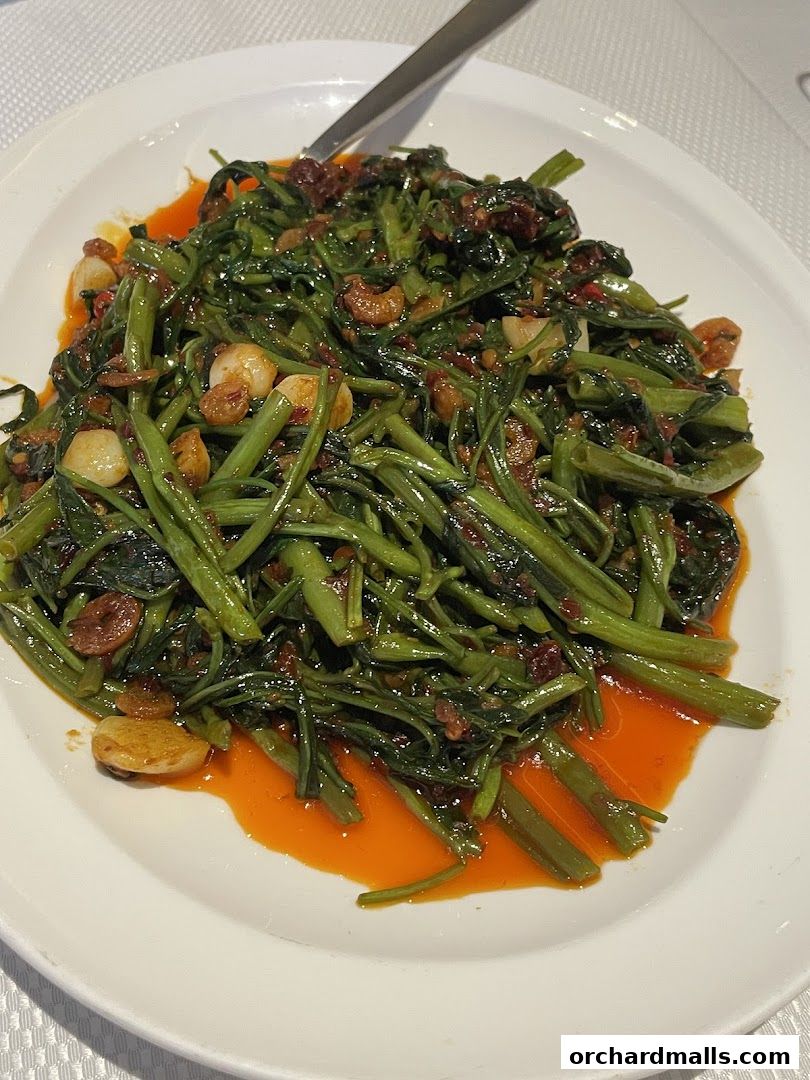 A plate of stir-fried water spinach with garlic and chili oil.