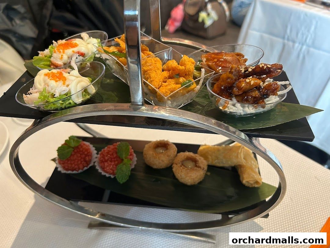 A tiered stand displays various appetizers, including seafood salad, fried items, and sweet treats.