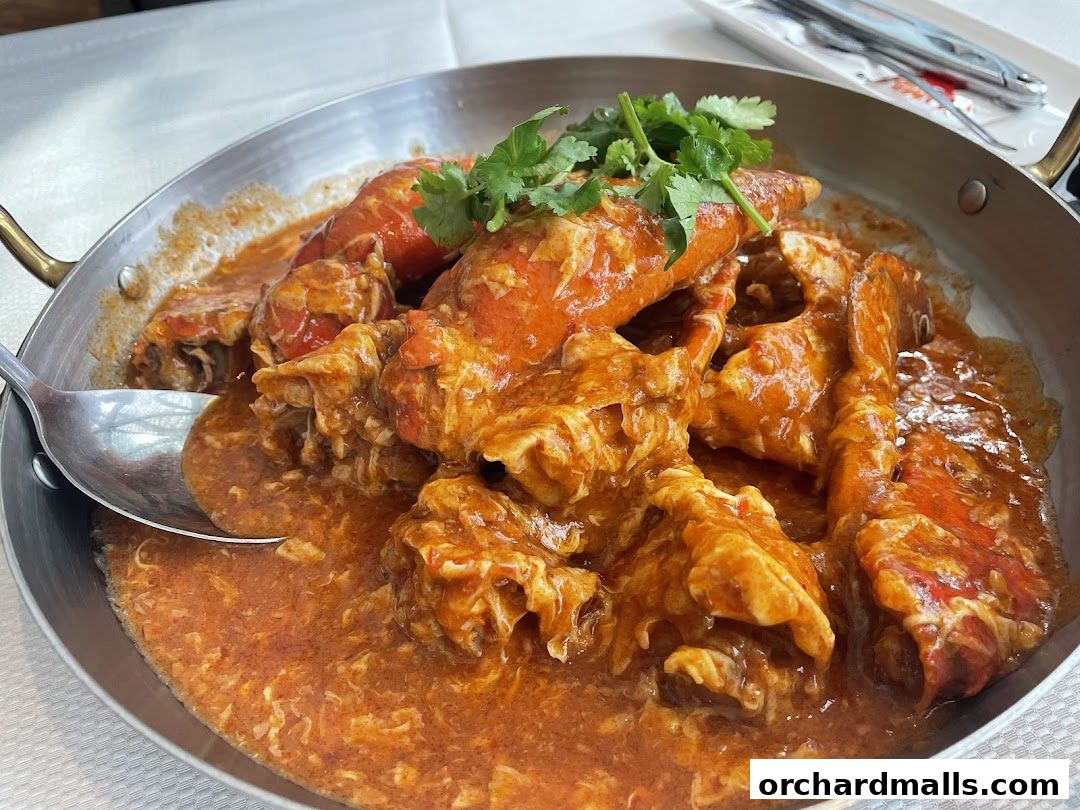 A close-up of a delicious seafood dish, likely chili crab, served in a metal pan.