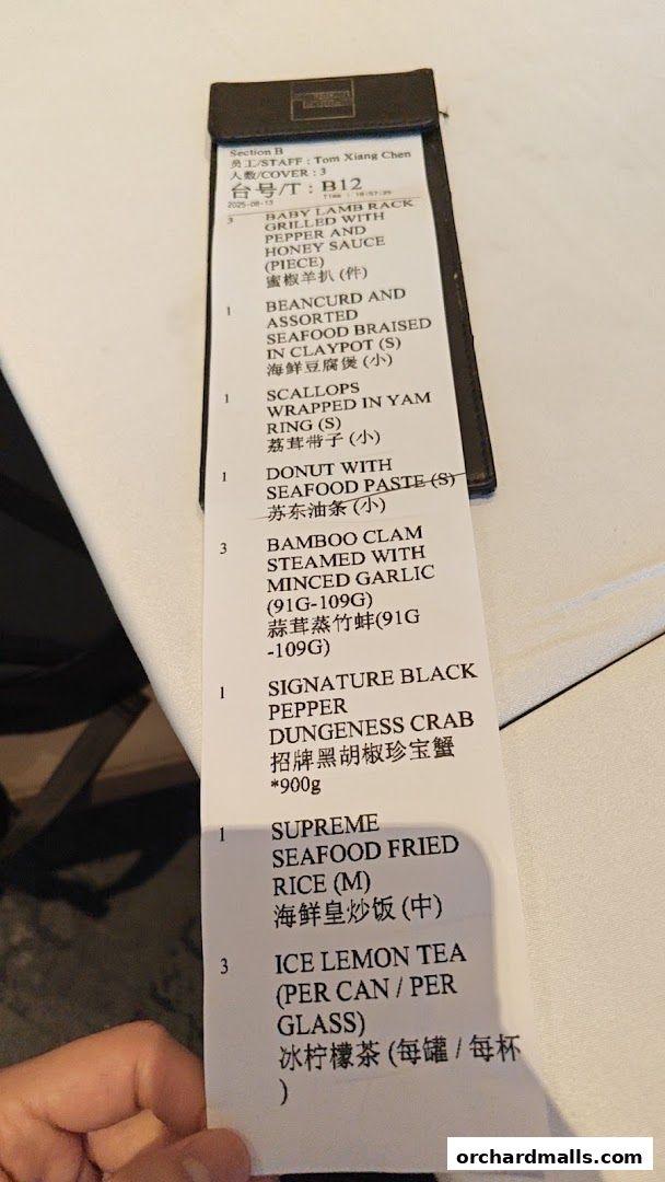 A close-up of a restaurant receipt listing various seafood dishes and drinks.