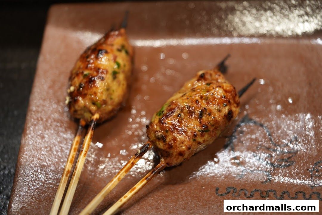 Two delicious yakitori skewers served on a brown plate, showcasing grilled chicken.