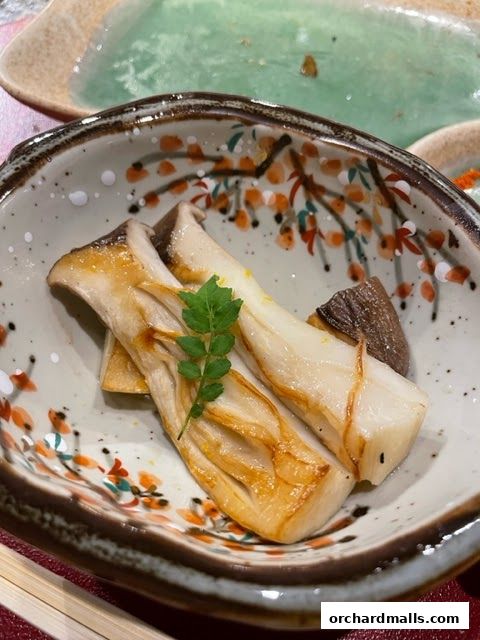 A close-up of grilled king oyster mushrooms served in a decorative bowl.