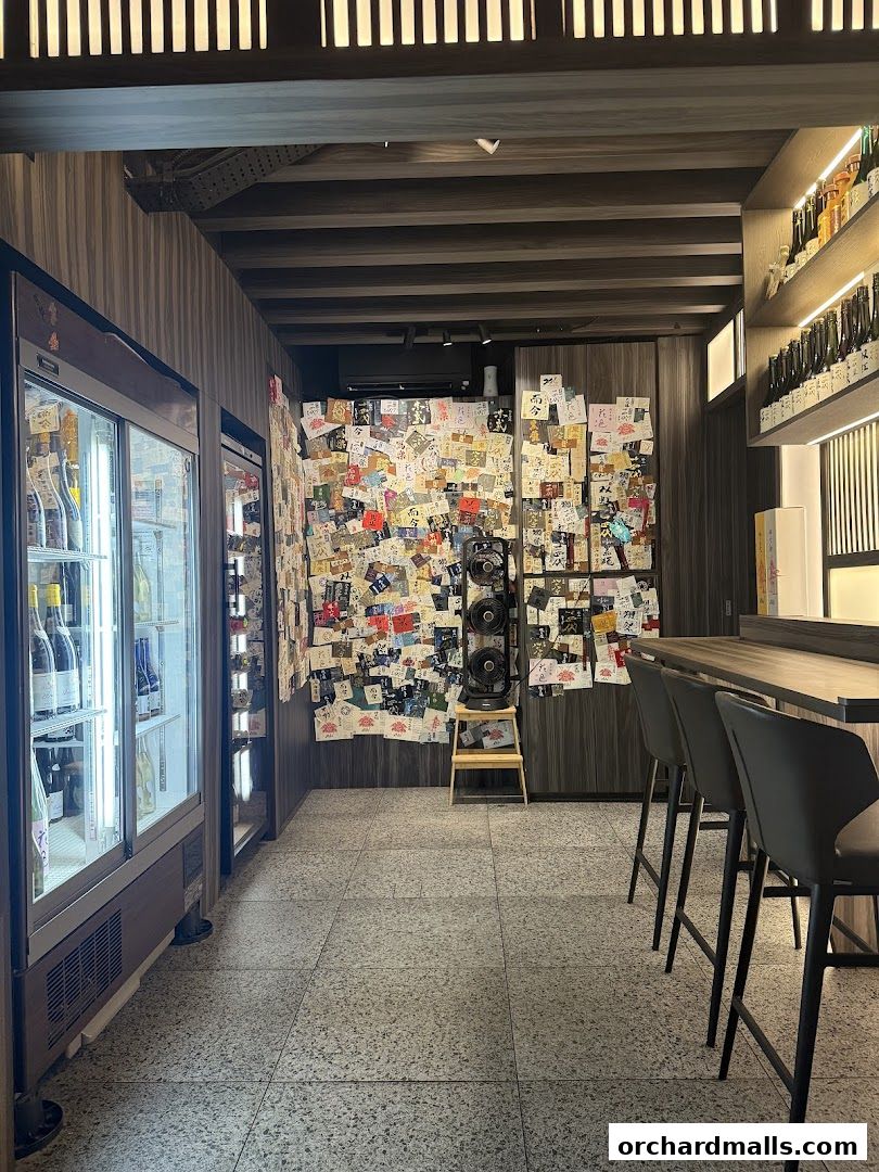 Interior of KAI Yakitori with a wall covered in notes and a bar with stools.