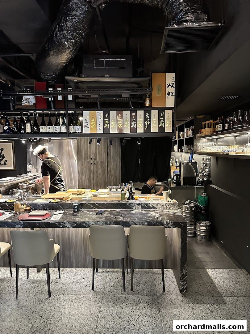 Interior of a modern Japanese restaurant with a sushi bar and seating.