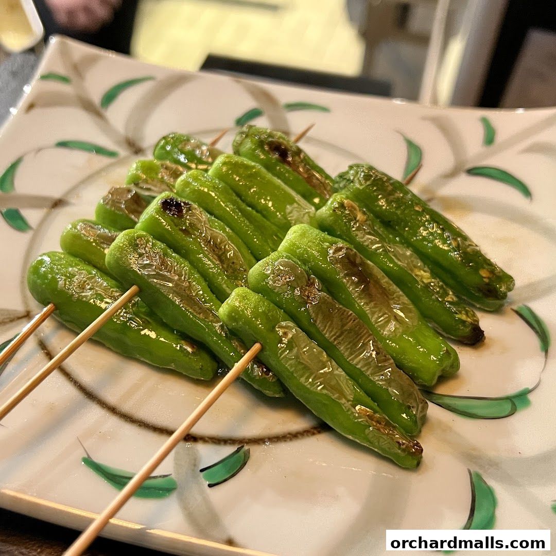 A plate of grilled green peppers on skewers, served at KAI Yakitori.