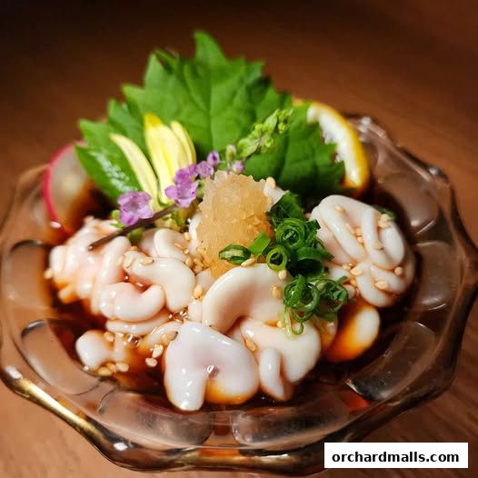 A close-up of a delicate seafood dish, garnished with herbs and lemon.