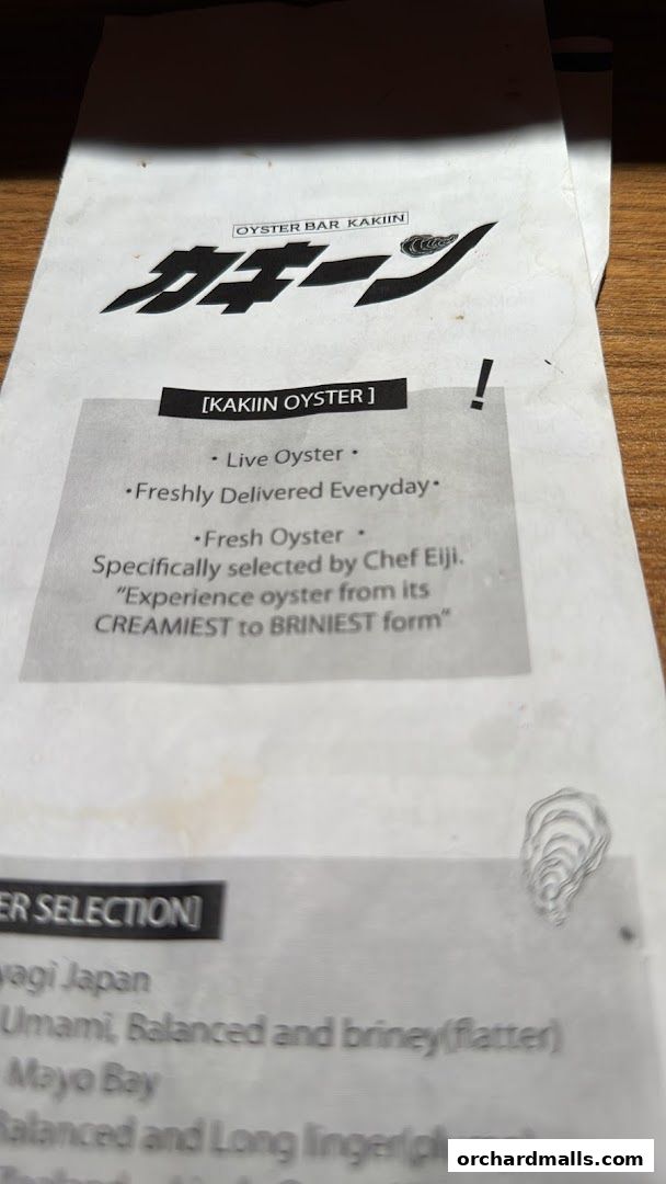 A menu from Kakiin Oyster Bar featuring live oysters and their selection.