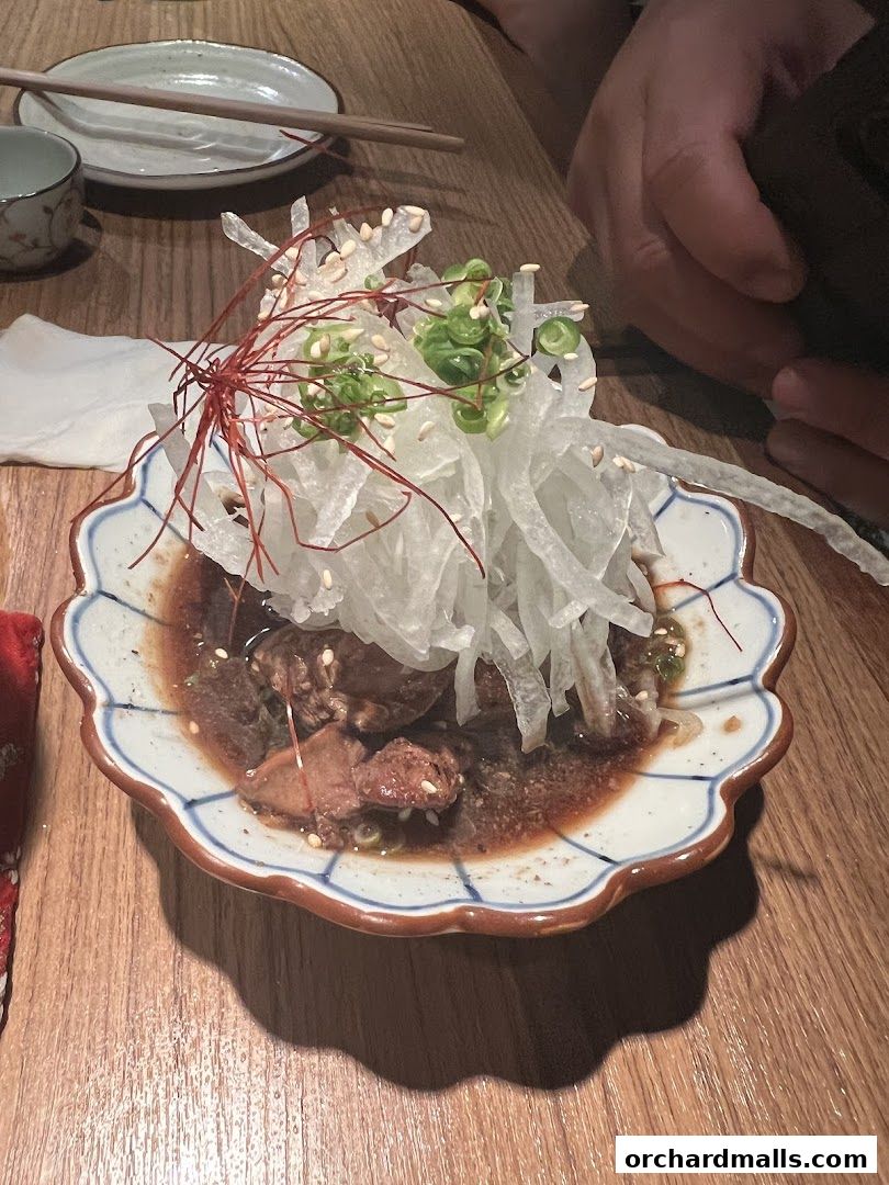 A close-up of a delicious dish with meat, vegetables, and garnishes served in a decorative bowl.
