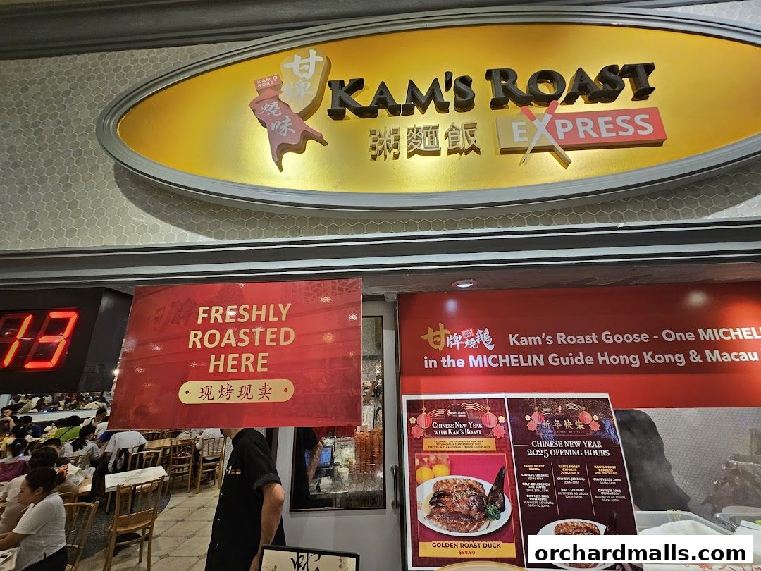 The exterior of Kam's Roast Express, featuring its prominent signage and promotional posters.