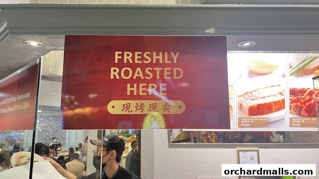A sign advertises freshly roasted food, with images of roast pork and chicken.