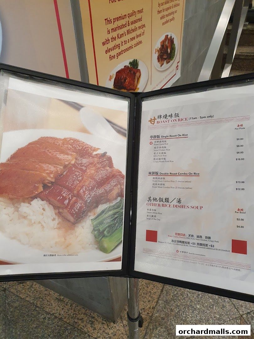 A menu board displaying roast meats on rice and other dishes with prices.