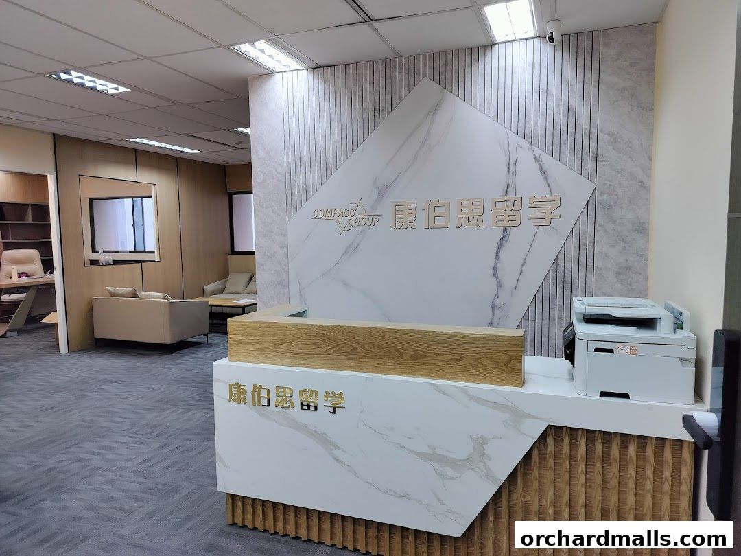 Interior of a modern office reception area with a marble-patterned wall and wooden accents.