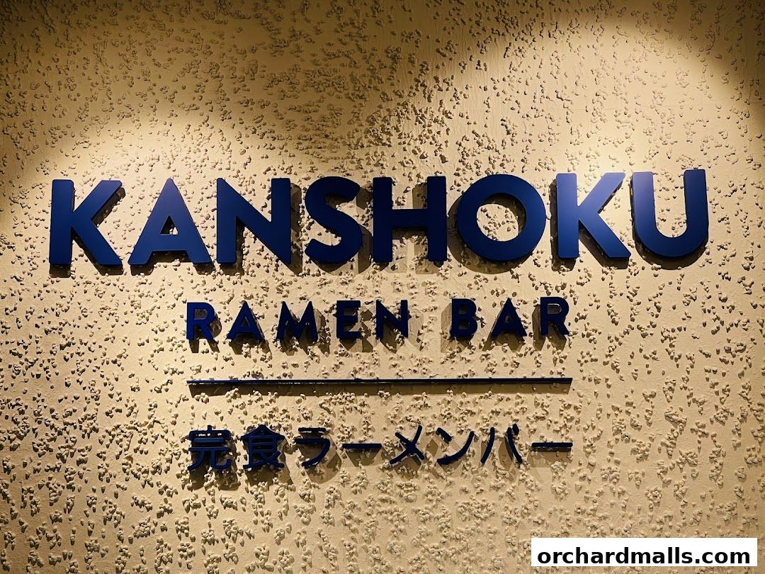 The Kanshoku Ramen Bar ION Orchard sign is displayed prominently on a textured wall.