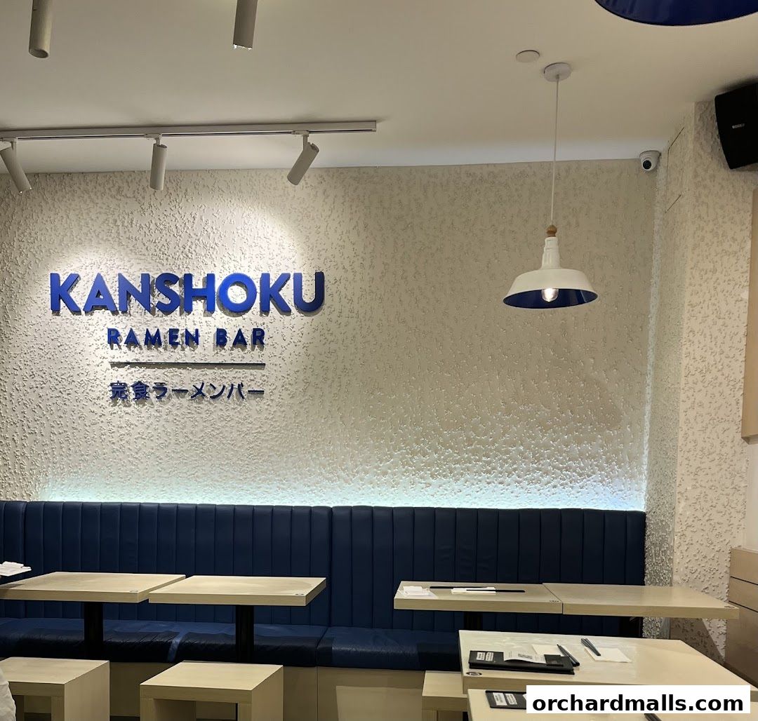 Interior of Kanshoku Ramen Bar with blue seating and tables.