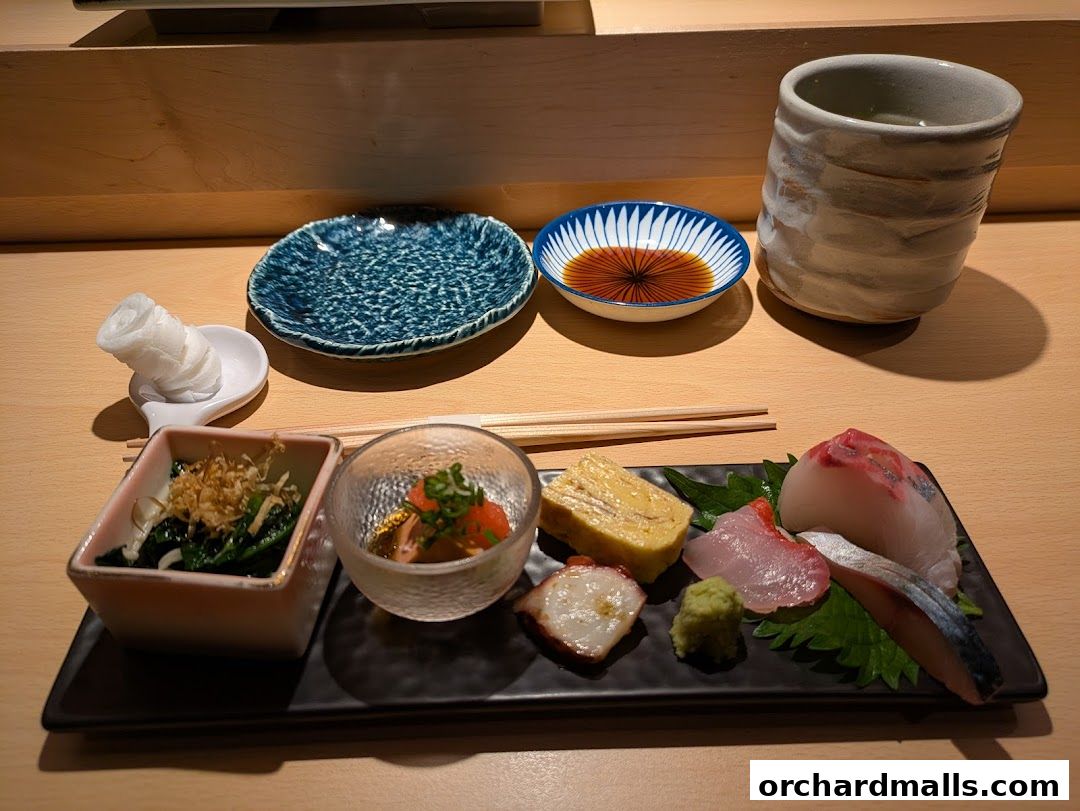 A beautifully presented sushi platter with various sashimi, tamagoyaki, and side dishes.