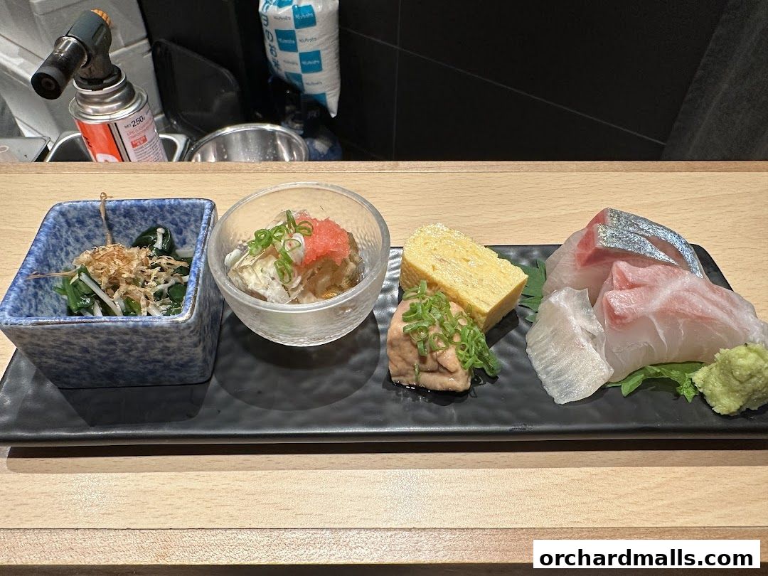 A platter of assorted Japanese dishes including sashimi, tamagoyaki, and small appetizers.