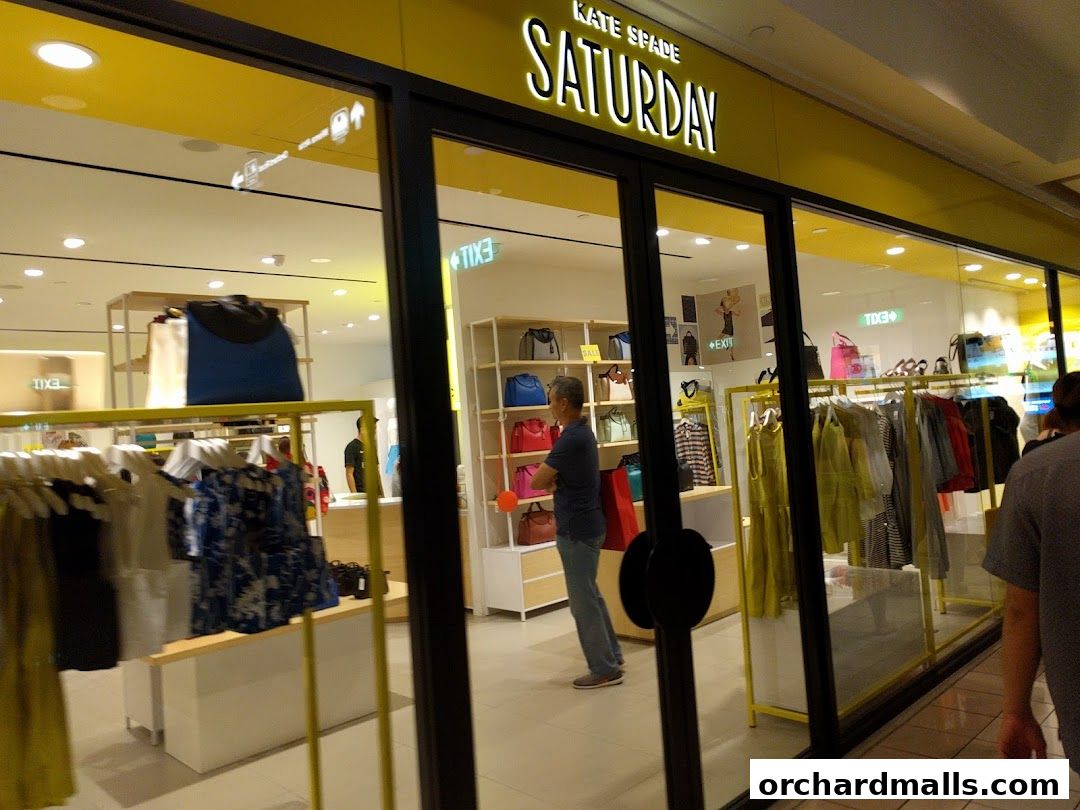 The exterior of a Kate Spade Saturday store with clothing and handbags displayed.