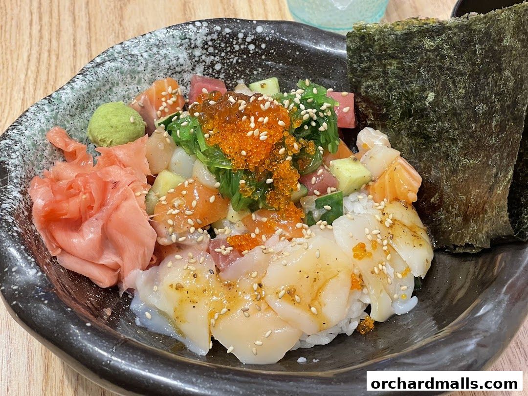 A bowl of Kaisendon with fresh seafood, ginger, wasabi, and seaweed.