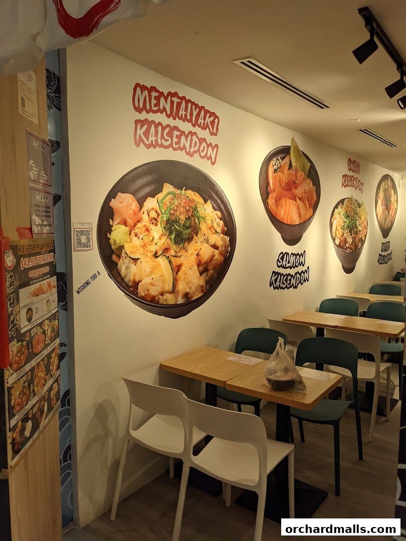 Interior of a Japanese restaurant with large food murals on the wall and dining tables.