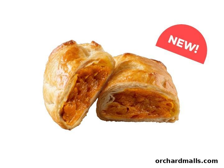 A golden-brown pastry, cut in half, revealing a vibrant orange filling. A red 'NEW!' sticker is visible.