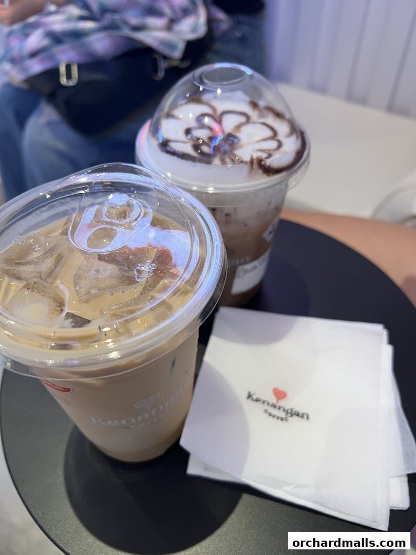 Two iced coffee drinks and a napkin with the Kenangan Coffee logo.