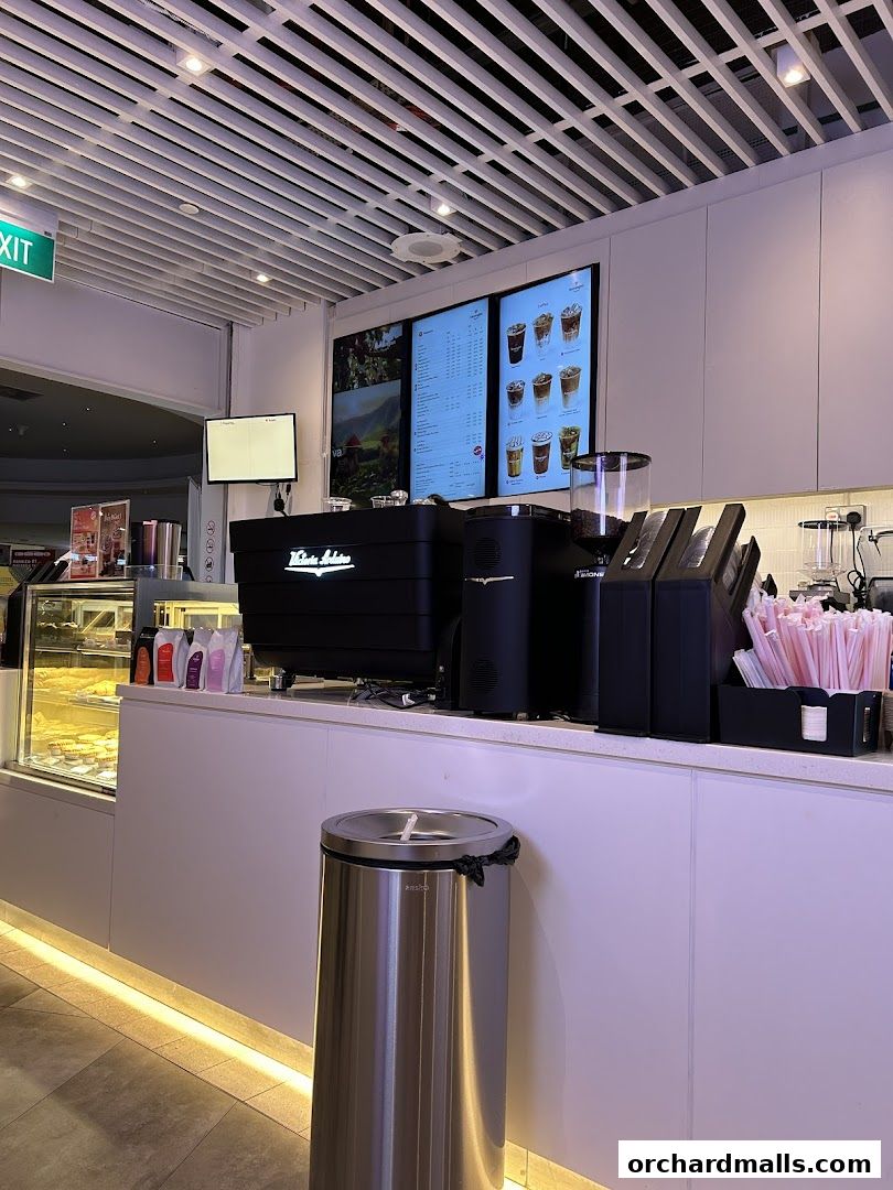 Interior view of Kenangan Coffee Takashimaya Shopping Centre with a digital menu and coffee machine.
