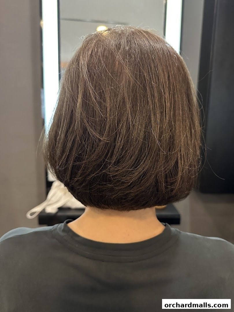 Back view of a person with a freshly styled bob haircut in a salon.