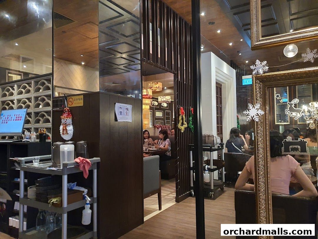 Interior view of a salon with seating areas, decorative elements, and a computer screen.