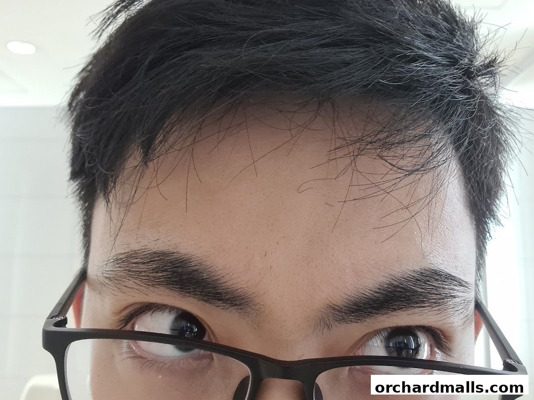 Close-up of a person's eyes and forehead wearing glasses.