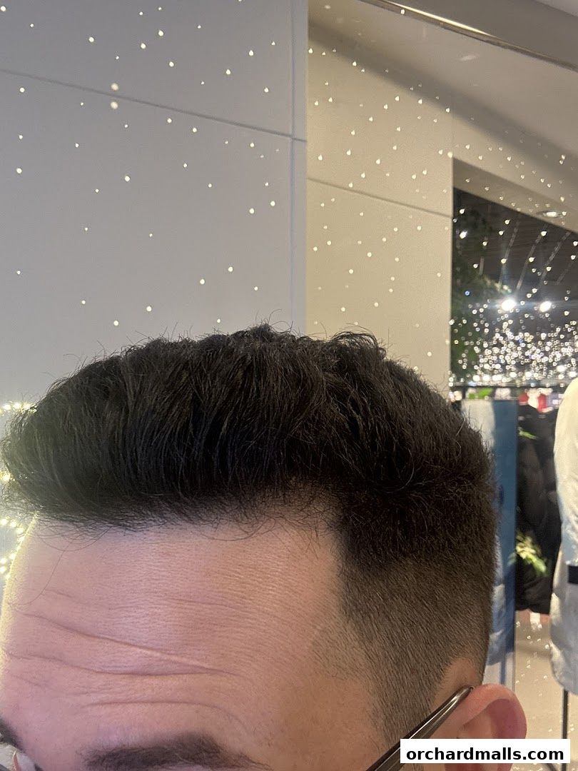 Close-up of a man's haircut with a modern fade and styled top.