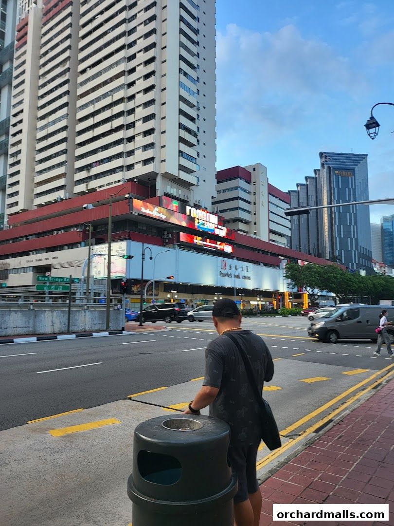 A street view of the Kent Holidays S Pte Ltd shop front with a tall building in the background.