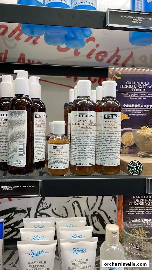 A display of Kiehl's skincare products, featuring Calendula Herbal-Extract Toner and Rare Earth Deep Pore Daily Cleanser.