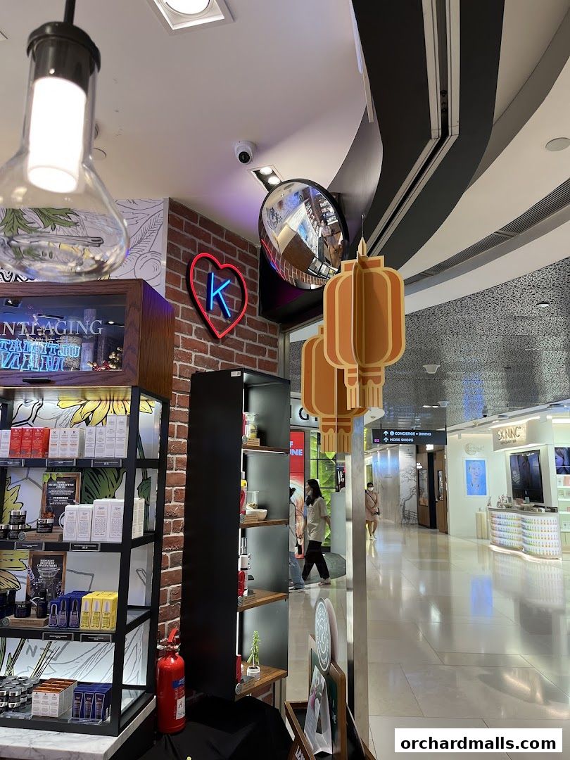Interior view of a Kiehl's store with products on display and shoppers in the background.