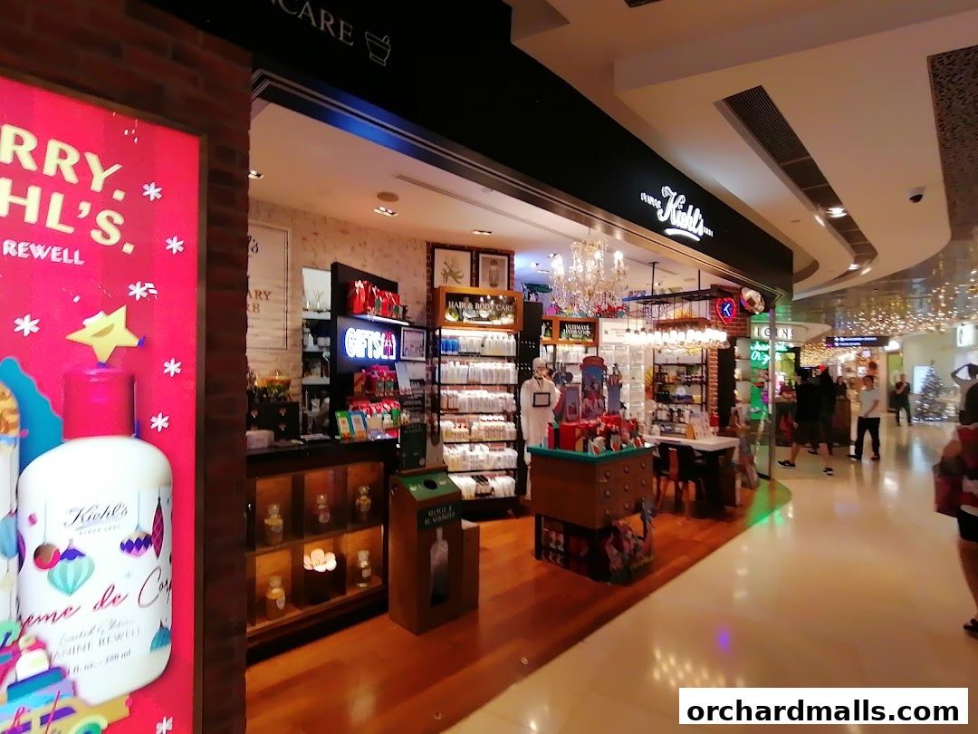 The interior of a Kiehl's store with products displayed and a festive advertisement.