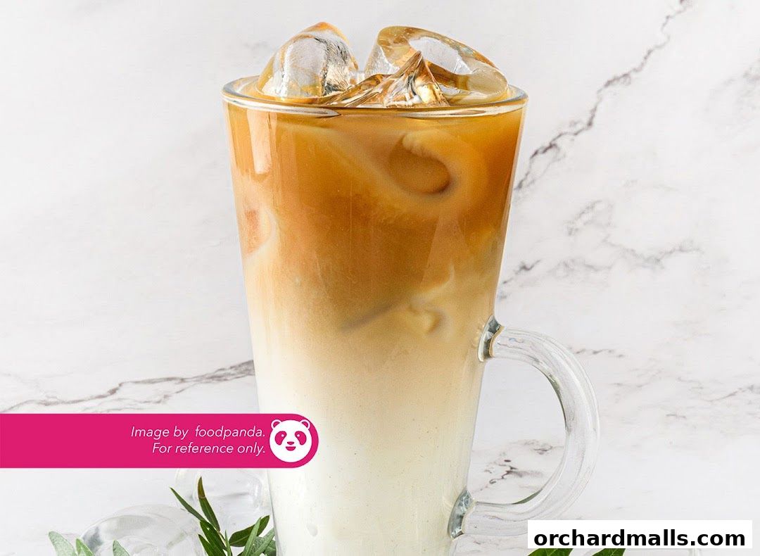 A tall glass of iced coffee with layers of milk and coffee, topped with ice.