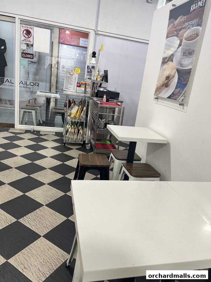 Interior view of Killiney Kopitiam with tables, chairs, and a counter.