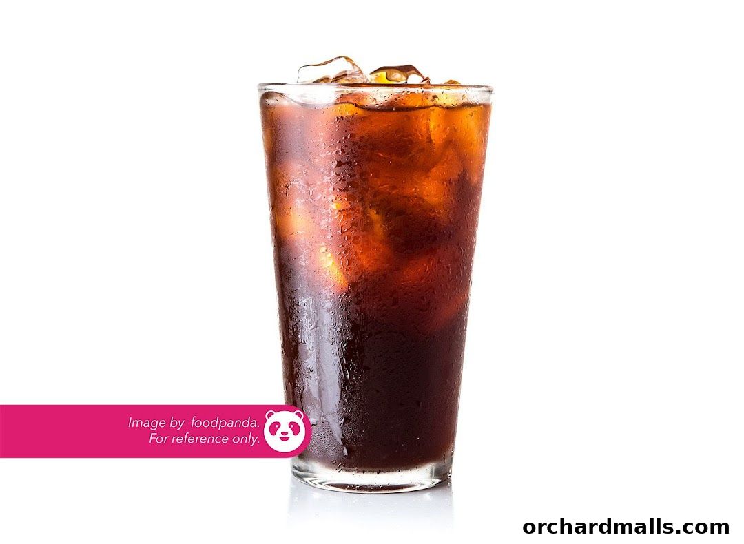 A tall glass of iced coffee with condensation on the glass.