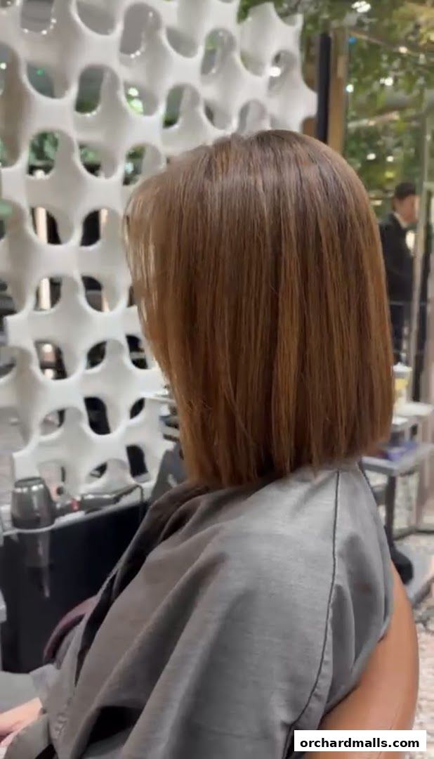 A person with a fresh, stylish bob haircut in a salon.