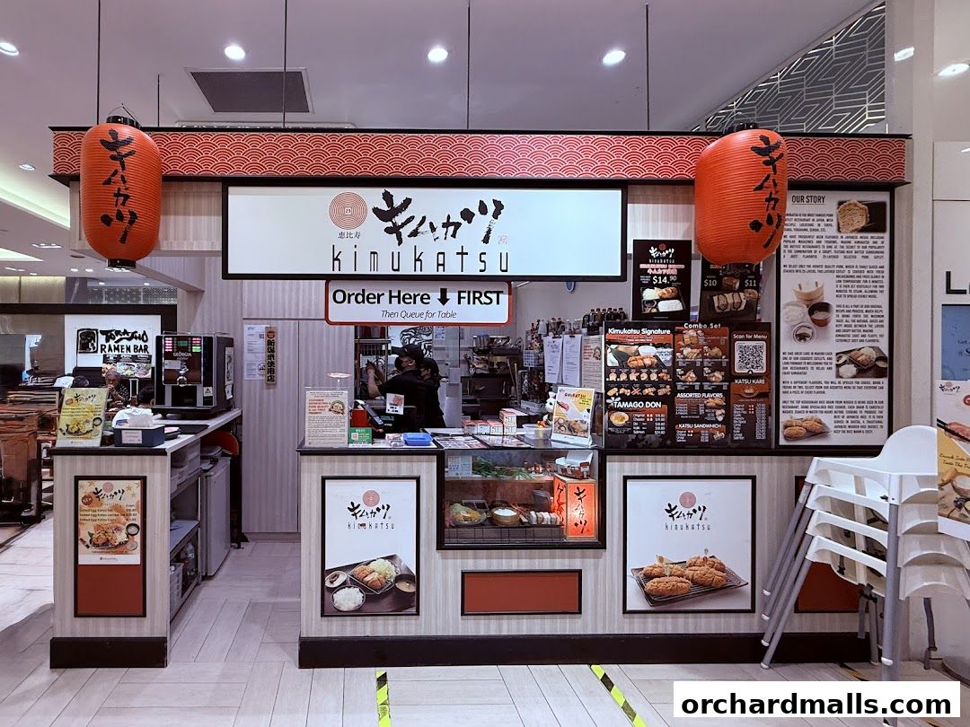 The Kimukatsu shop front with menu displays and staff preparing food.