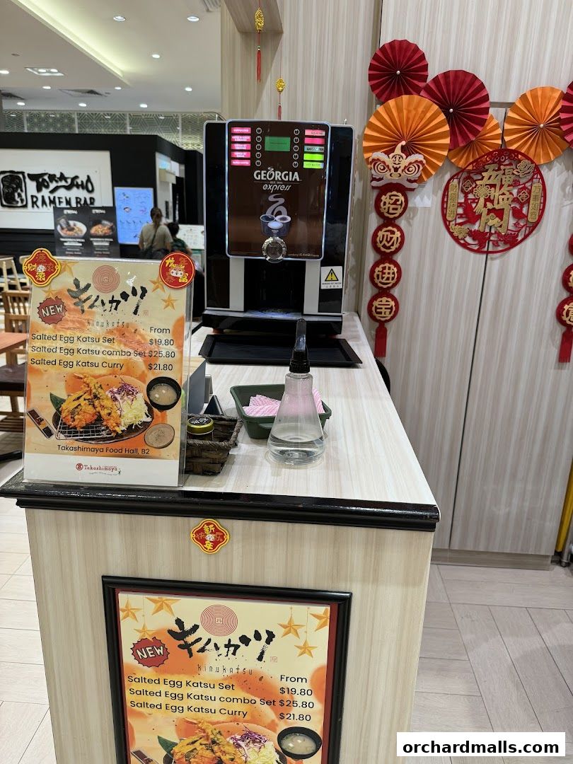 A display featuring menu items from KIMUKATSU, including Salted Egg Katsu sets and curry.