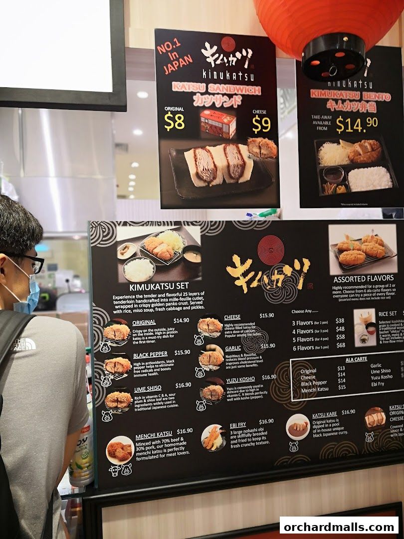 A customer looks at a menu board for Kimukatsu, showcasing katsu sandwiches, bentos, and sets.