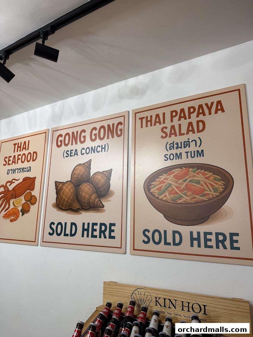 Signs for Thai food items like seafood, conch, and papaya salad, with bottles below.