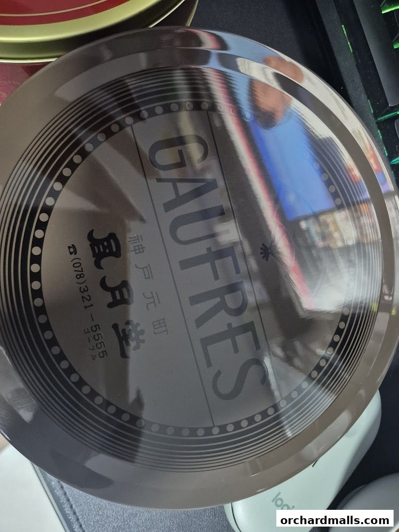 A round tin can with 'GAUFRES' and Japanese text, likely containing cookies.