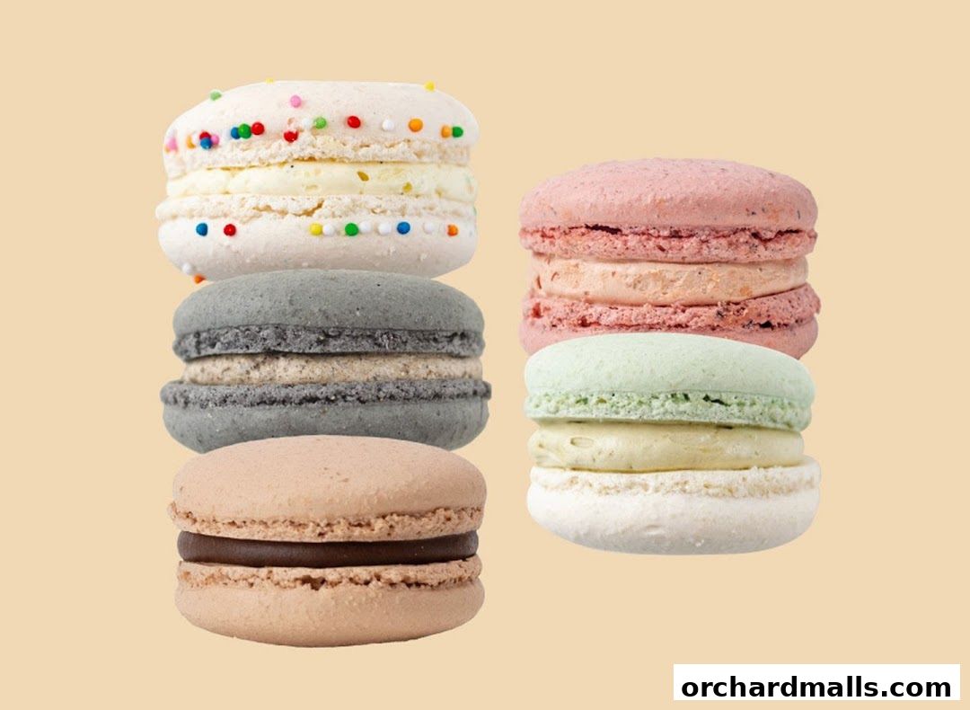 A selection of colorful macarons stacked in pairs against a plain background.
