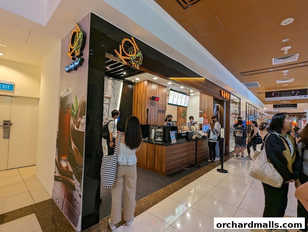 KOI Thé Express Takashimaya shop front with customers queuing and staff serving drinks.