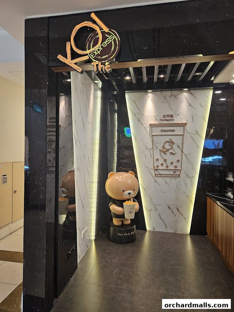 The entrance of KOI Thé Express Takashimaya, featuring a cute bear mascot holding a drink.