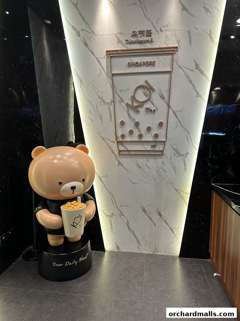 KOI Thé Express Takashimaya shop entrance with a bear mascot and logo.