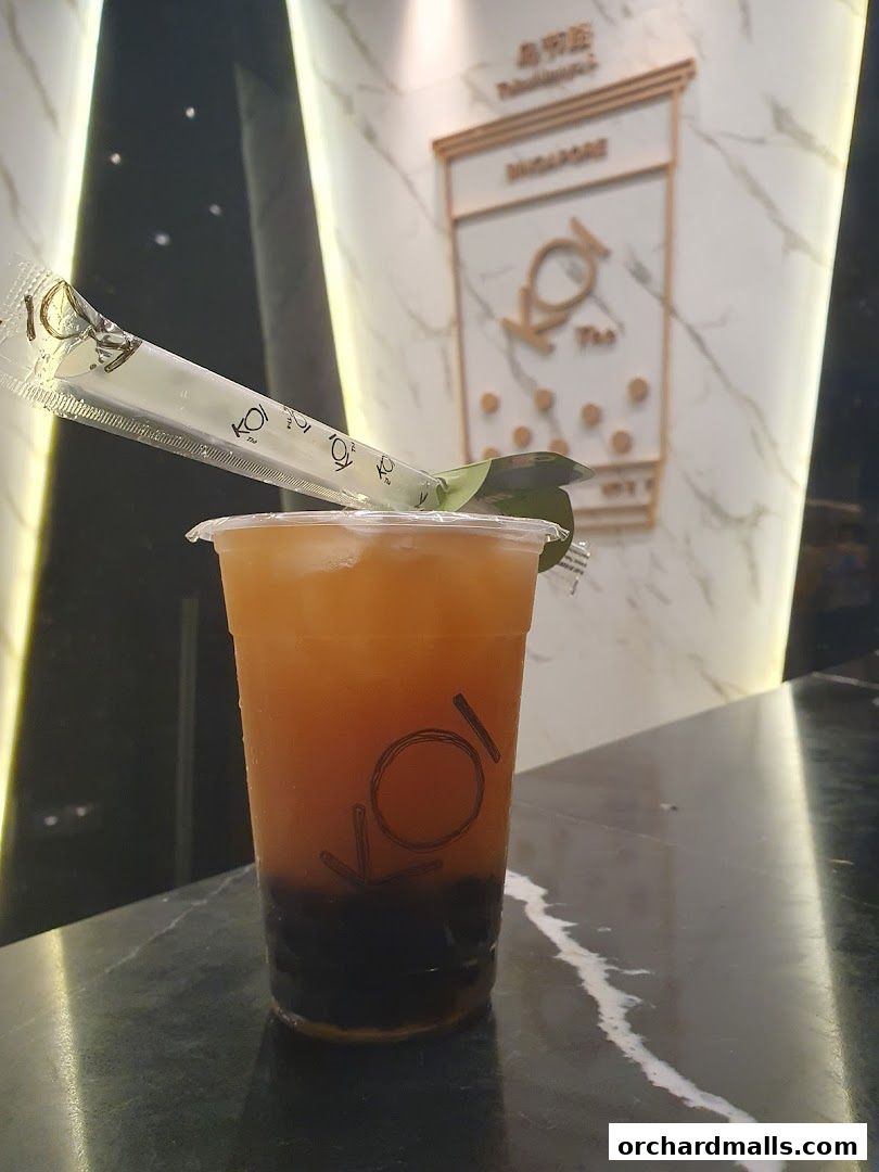 A refreshing KOI Thé bubble tea with tapioca pearls and a branded straw.